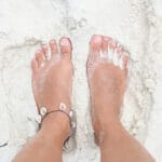 Feet on the white sand.
